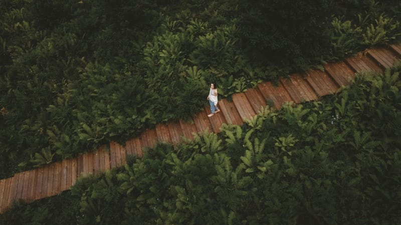 Person walking lightly on a trail, representing balance and long-term healthy habits”